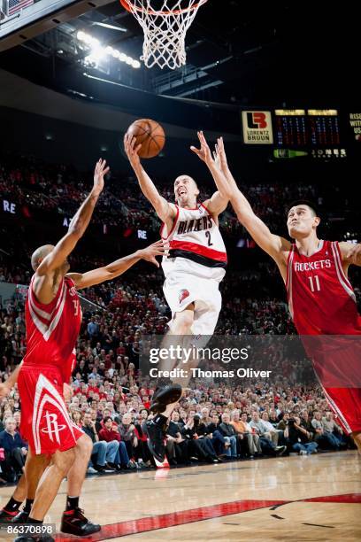 Steve Blake of the Portland Trail Blazers lays up a shot between Shane Battier and Yao Ming of the Houston Rockets in Game Five of the Western...