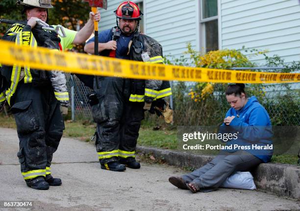 Victoria Cann waits to speak with Red Cross volunteers as firefighters pack up their gear following a fire on Island Avenue in Sanford on Thursday,...