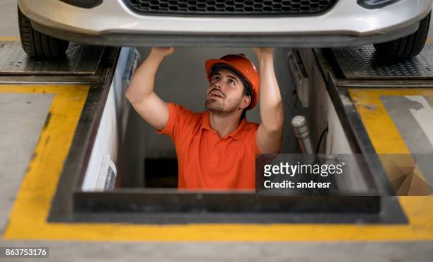 mechanic fixing a car at an auto repair shop - chassis stock pictures, royalty-free photos & images