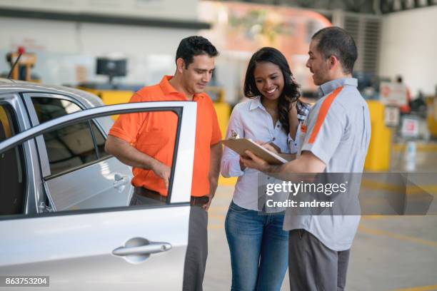 woman taking her car to the auto repair shop - happy client by broken car stock pictures, royalty-free photos & images