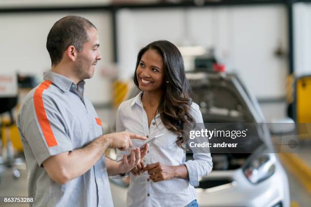 frau, die ihr auto zu der mechaniker - happy client by broken car stock-fotos und bilder