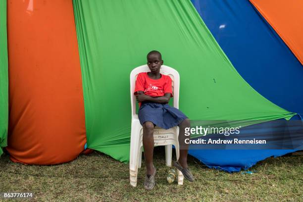 Girl sits outside the main tent of a rally for opposition candidate Raila Odinga at the Ogango Grounds on October 20, 2017 in Kisumu, Kenya. Tensions...