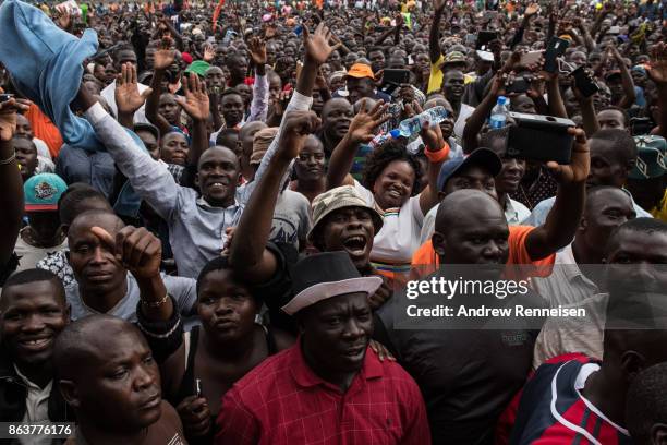 Supporters cheer as opposition candidate Raila Odinga speaks to the crowd gathered at a rally at the Ogango Grounds on October 20, 2017 in Kisumu,...