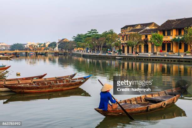 vietnamese woman paddling in old town in hoi an city, vietnam - vietnam stock pictures, royalty-free photos & images