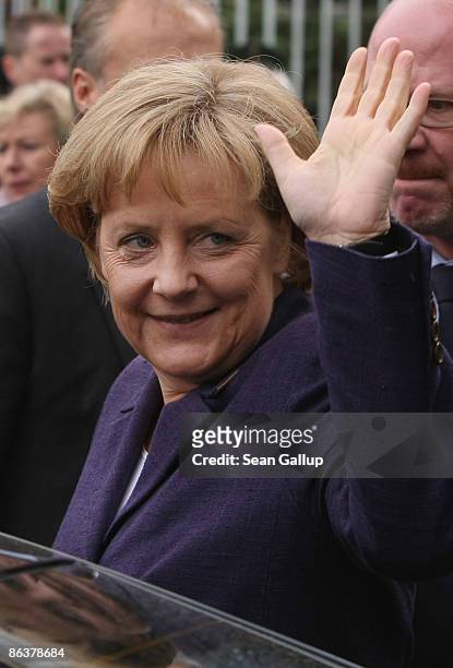 German Chancellor Angela Merkel waves to onlookers after touring the former prison of the East German, communist-era secret police, known as the...