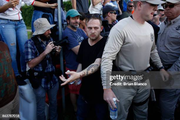 Self-described white nationalist Colton Fears, of Pasadena, Texas, center, walks behind Florida Highway Patrol troopers as the troopers assist his...