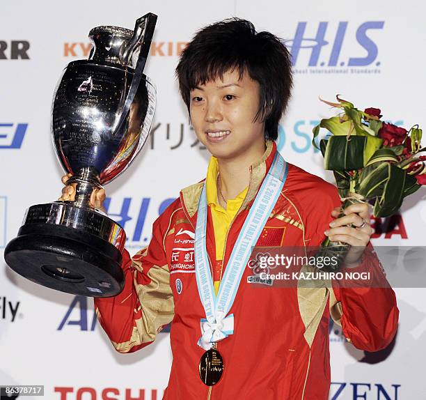 Chinese world number one player Zhang Yining holds up championship trophy during the awards ceremony after winning the women's singles final at the...