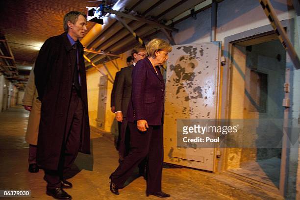 German Chancellor Angela Merkel is followed by current prison memorial director Hubertus Knabe and State Secretary Andre Schmitz while touring the...