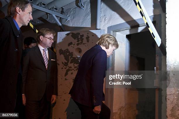 German Chancellor Angela Merkel is followed by current prison memorial director Hubertus Knabe and State Secretary Andre Schmitz while touring the...