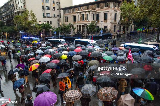 General view of the protesters is seen as they holds umbrella front of the Government Delegation surrounded by Police van during a gathering. Despite...