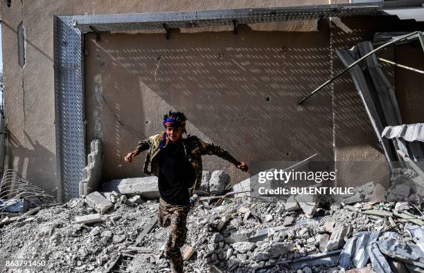 Fighters of the Syrian Democratic Forces gather at the stadium in Raqa to celebrate on October 20 after retaking the city from Islamic State group...