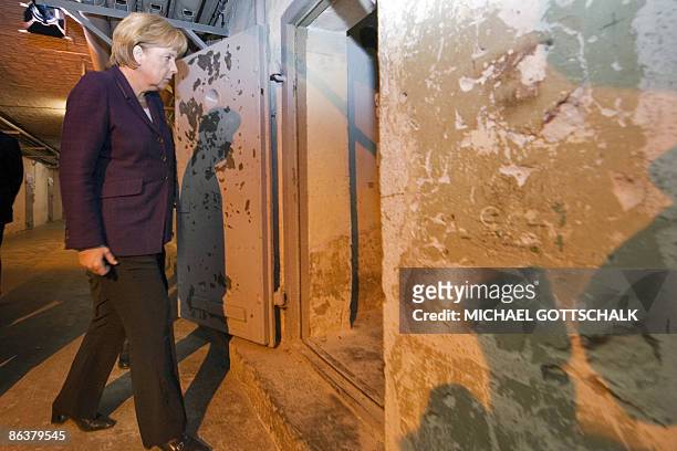 German Chancellor Angela Merkel enters a prison cell as she visits the memorial site at the former Stasi, East German secret police in Berlin's...