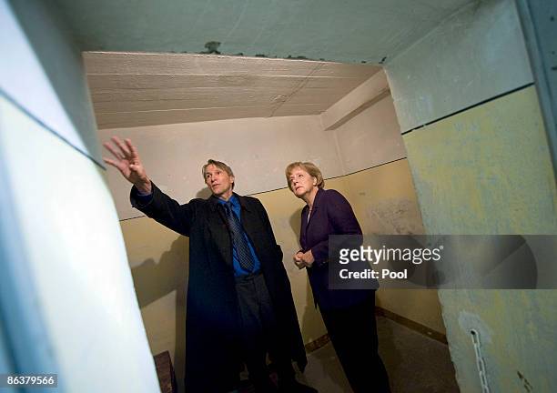 Prison memorial director Hubertus Knabe shows German Chancellor Angela Merkel the former prison of the East German, communist-era secret police,...