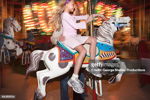 mother and daughter on a carousel - flash ストックフォトと画像
