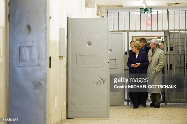 German Chancellor Angela Merkel inspects a prison cell with former prisoner Gilbert Furian as she visits the memorial site at the former Stasi, East...