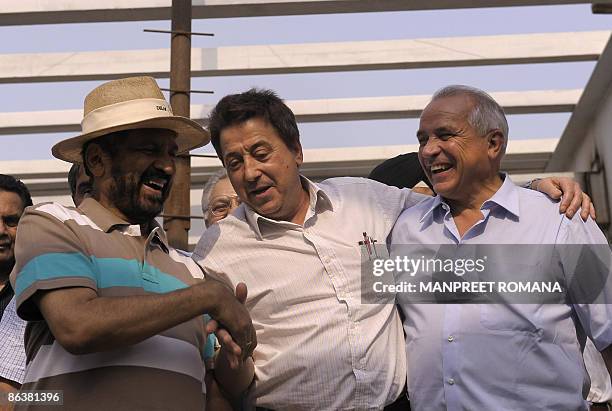 Indian Olympic Association President Suresh Kalmadi shake hands with Indian hocky coach Jose Brasa as International Hockey Federation President...