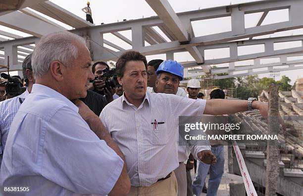 Indian hockey coach Jose Brasa gestures as he chats with International Hockey Federation President Leandro Negre during their visit to Dhyan Chand...