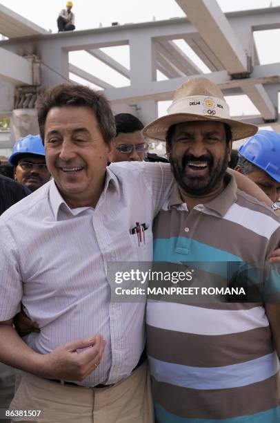 Indian hockey coach Jose Brasa hugs Indian Olympic Association President Suresh Kalmadi during their visit to Dhyan Chand National Stadium to inspect...