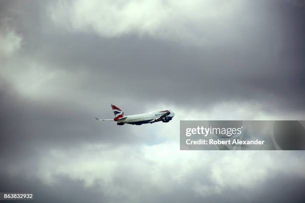 British Airways passenger plane flies into the clouds after lifting off from Heathrow International Airport in London, England.