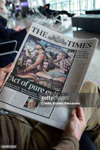 An airplane passenger waiting to board a flight at Heathrow International Airport in London, England, reads a copy of the London tabloid newspaper,...