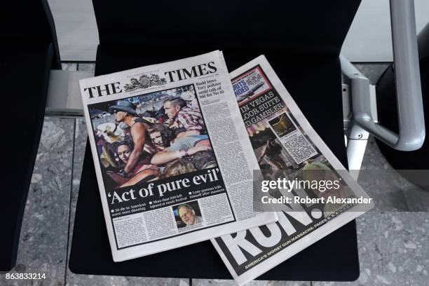 Copies of the English tabloid newspapers The Times and The Sun are left on a seat in the terminal at Heathrow International Airport in London,...