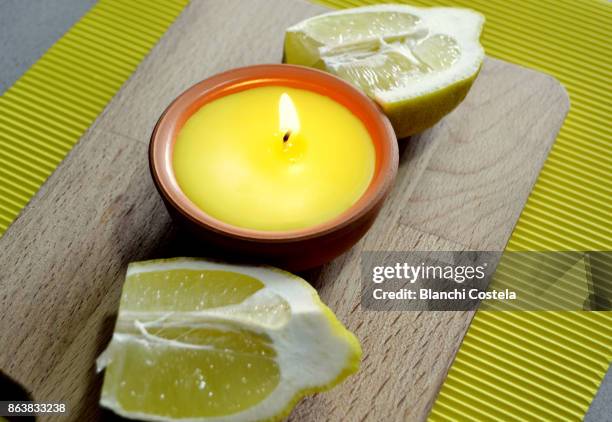 citronella candle lit and lemon fruit - lemongrass stockfoto's en -beelden