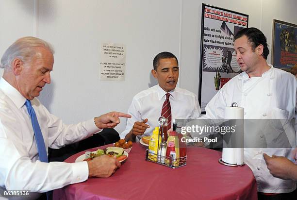 President Barack Obama and U.S. Vice President Joe Biden sit at a table as they are served their cheeseburger lunch orders at Ray's Hell Burger May...