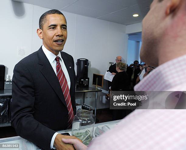 President Barack Obama shakes hands with cashier Tim Murray as he orders lunch at Ray's Hell Burger May 5, 2009 in Arlington, Virginia. Obama and...