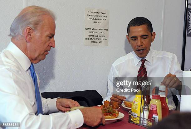 President Barack Obama and U.S. Vice President Joe Biden sit at a table with their cheeseburger lunch orders at Ray's Hell Burger May 5, 2009 in...