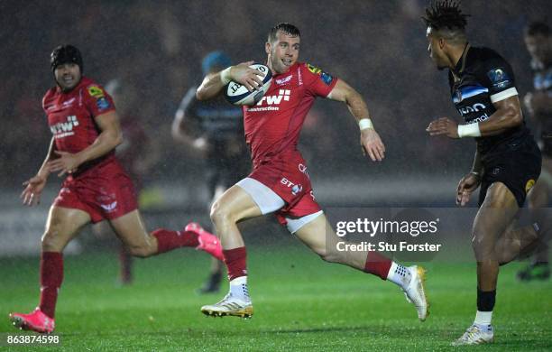 Scarlets scrum half Gareth Davies breaks past Anthony Watson to set up the first try during the European Rugby Champions Cup match between Scarlets...