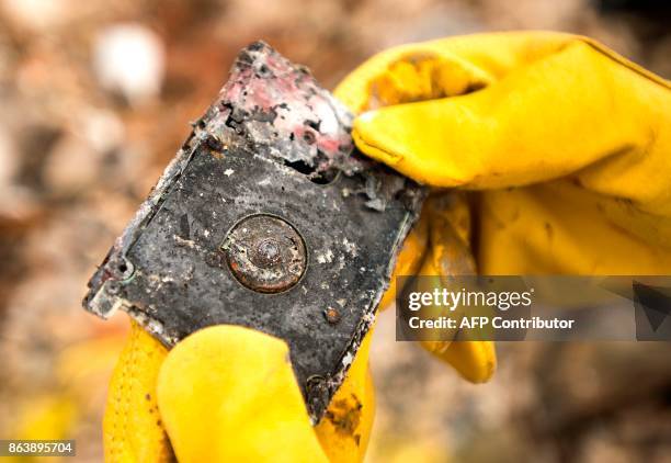 Barbara Wilson Nichols finds a burnt hard drive as she searches through the remains of her home in the Coffey Park area of Santa Rosa, California on...