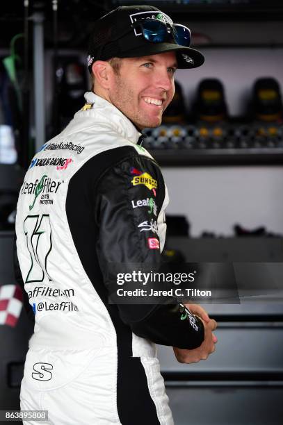 Blake Koch, driver of the Breat Cancer Honor & Remember Chevrolet, stands in the garage area during practice for the NASCAR XFINITY Series Kansas...