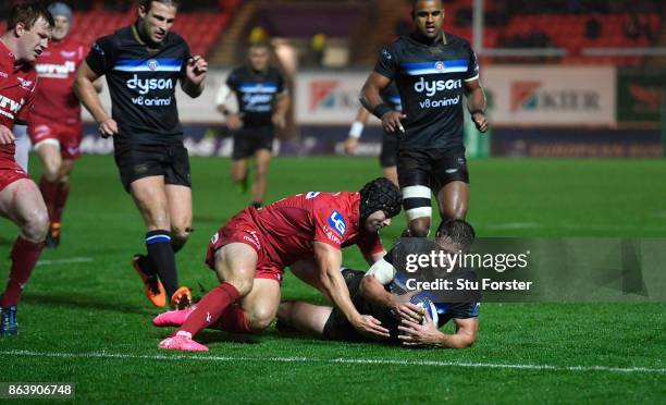 Bath player Rhys Priestland has his slide towards the line stopped by Leigh Halfpenny during the European Rugby Champions Cup match between Scarlets...