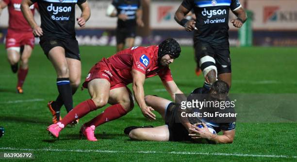 Bath player Rhys Priestland has his slide towards the line stopped by Leigh Halfpenny during the European Rugby Champions Cup match between Scarlets...