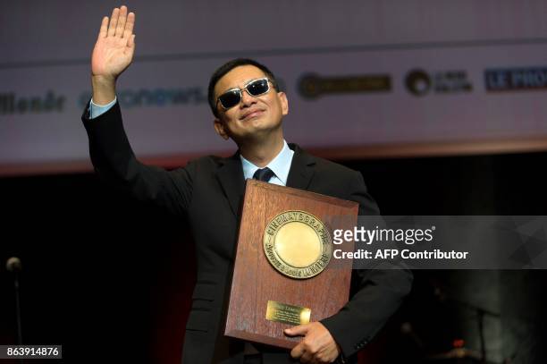 Chinese Director Wong Kar-wai holds his trophy after receiving the Lumiere Award during the 9th edition of the Lumiere Film Festival, on October 20,...