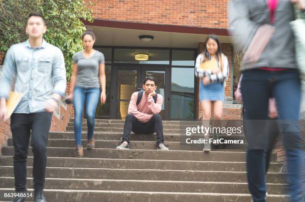 dejected college student sits alone on stairs - walking away from camera stock pictures, royalty-free photos & images