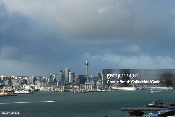 Urban skyline of Auckland, New Zealand, including the iconic Sky Tower, from across Auckland Harbor on Mount Victoria on an overcast day, with cruise...