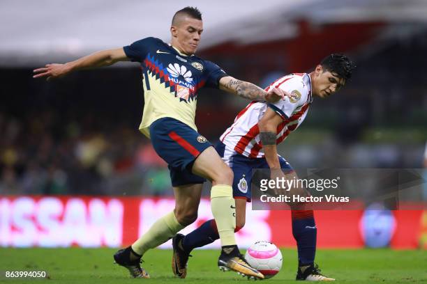 Mateus Uribe of America struggles for the ball with Alan Pulido of Chivas during the 10th round match between America and Chivas as part of the...
