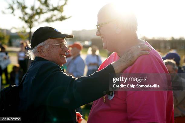 Anti-war activists Paul Lauter and Bruce Beyer embrace during a vigil commeorating the 50th anniversary of the 1967 March on the Pentagon outside the...