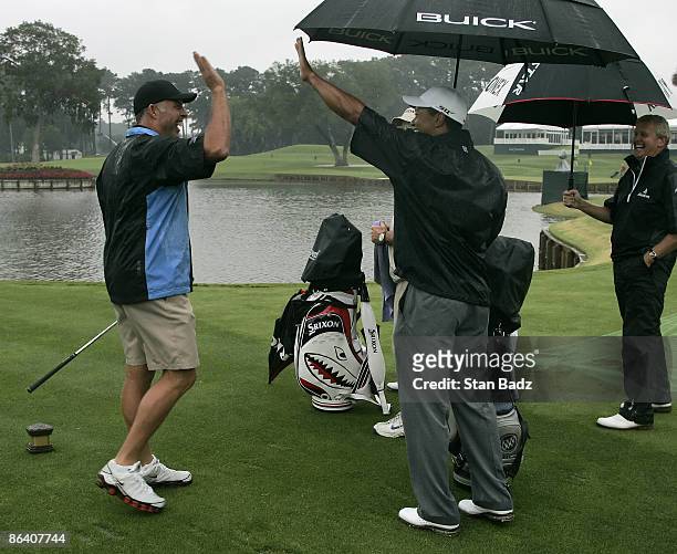Steve Williams hit nearest to the pin at the 17th green and gets high fives from Tiger Woods during practice for THE PLAYERS Championship held on THE...