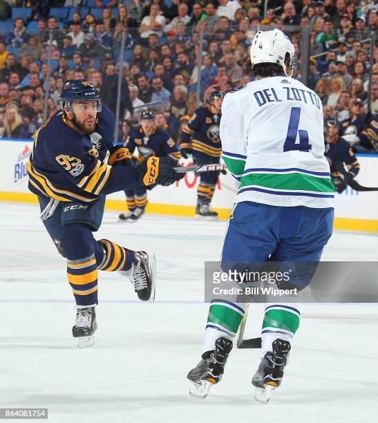Justin Bailey of the Buffalo Sabres shoots the puck while defended by Michael Del Zotto of the Vancouver Canucks during an NHL game on October 20,...