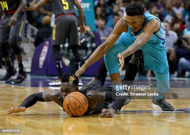 Malik Monk of the Charlotte Hornets goes after a loose ball against Dennis Schroder of the Atlanta Hawks during their game at Spectrum Center on...