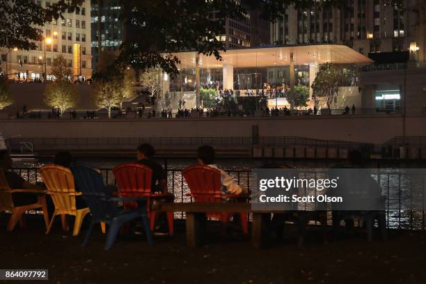 People watch from the opposite bank as guests attend the grand opening of Apple's Chicago flagship store on Michigan Avenue October 20, 2017 in...