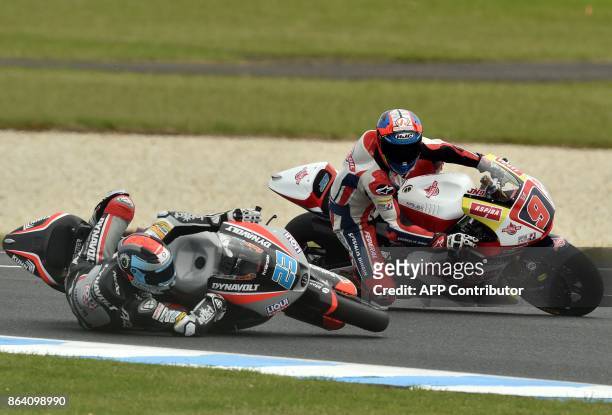 Suter rider Marcel Schrotter of Germany crashes as Federal Oil Gresini Kalex rider Jorge Navarro of Spain looks on during the Moto2-class third...