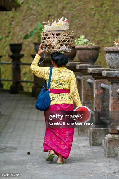 rear view portrait of balinese woman carrying basket on head - bali women tradition head stock pictures, royalty-free photos & images