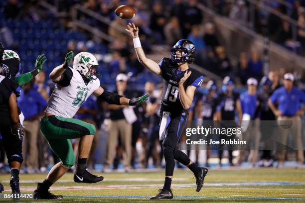 John Urzua of the Middle Tennessee Blue Raiders looks to pass while under pressure from Ryan Bee of the Marshall Thundering Herd in the third quarter...