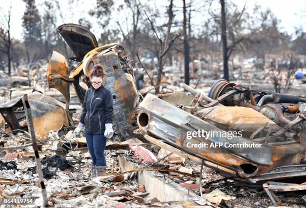 Resident who declined to give her name walks near flipped cars at her burned property in Santa Rosa, California on October 20, 2017. Residents are...