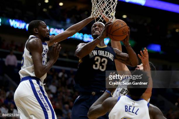 Dante Cunningham of the New Orleans Pelicans shoots over Kevin Durant of the Golden State Warriors and Zaza Pachulia of the Golden State Warriors...
