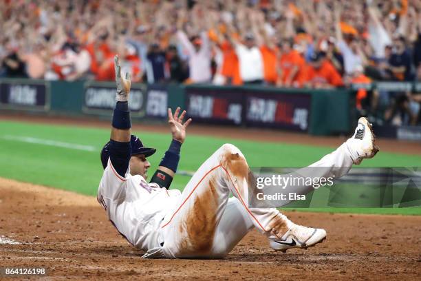 Yuli Gurriel of the Houston Astros celebrates as he slides home to score off of a double hit by Alex Bregman against David Robertson of the New York...