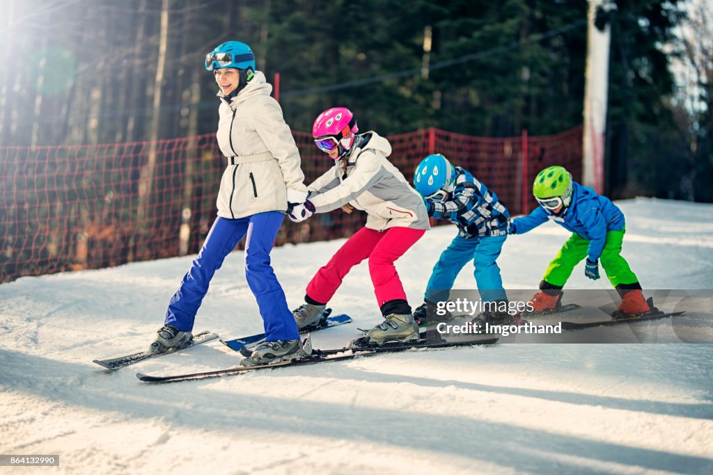 Kids practicing skiing with ski school instructor